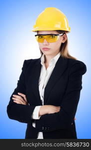 Young businesswoman with hard hat on white