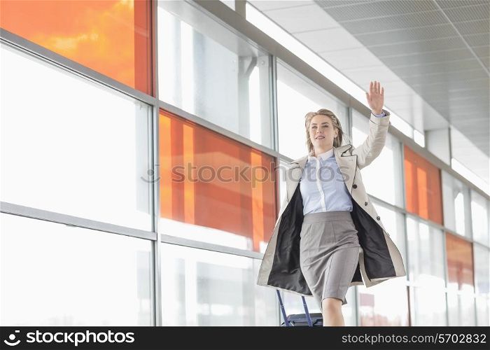 Young businesswoman with luggage running in railroad station