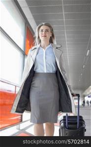 Young businesswoman with luggage walking in railroad station