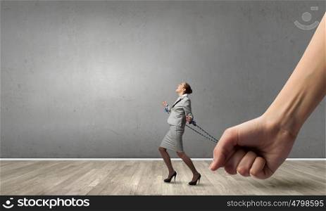 Young businesswoman with ropes on hands trying to escape. With tied hands