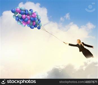 Young businesswoman with suitcase and bunch of colorful balloons. Taking break from business