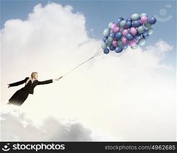Young businesswoman with suitcase and bunch of colorful balloons. Taking break from business