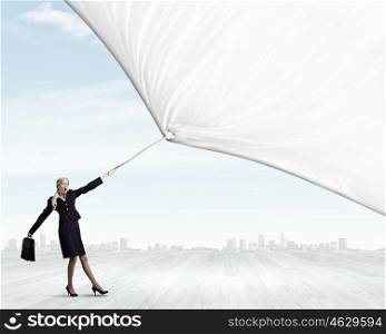Young businesswoman with suitcase pulling white blank banner. Place for your text