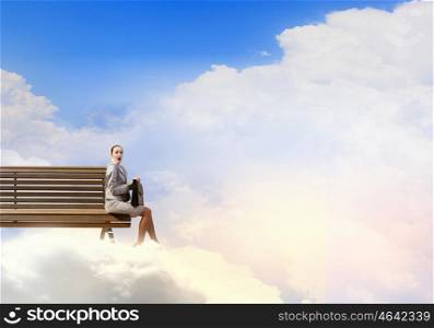Young businesswoman with suitcase sitting on bench. Taking break from office