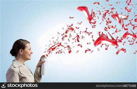 Young businesswoman with suitcase using spray balloon. Young businesswoman spraying red shoes from aerosol balloon