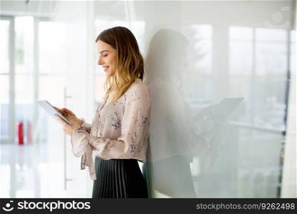 Young businesswoman with tablet in modern office
