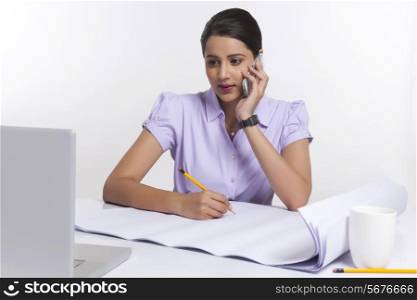 Young businesswoman working at desk over white background