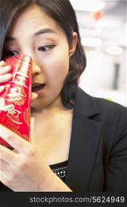 Young businesswomen looking into traditional red envelopment, Chinese New Year