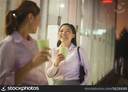 Young businesswomen smiling and drinking coffee outdoor