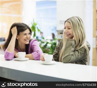 Young businesswomen smiling at cafeteria table