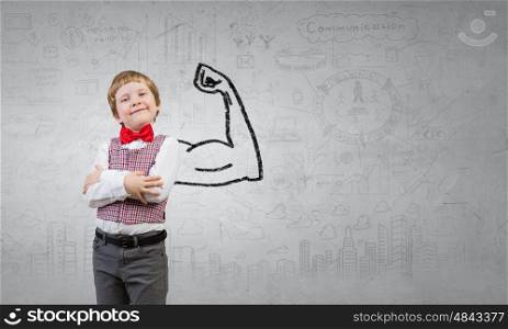 Young but strong enough. Portrait of little boy with hands folded on chest