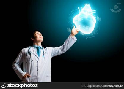 Young cardiologist. Image of male doctor touching media image