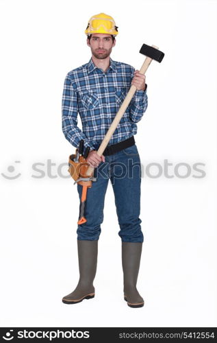 young carpenter in studio holding hammer