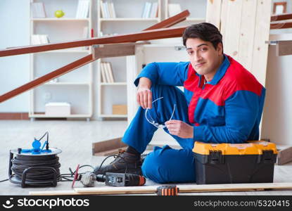 Young carpenter taking break from working with wooden planks