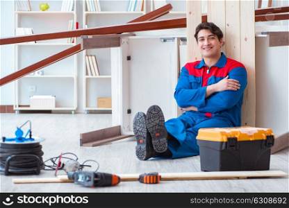Young carpenter taking break from working with wooden planks