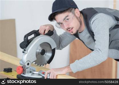 Young carpenter using circular saw