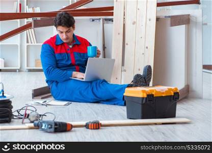 Young carpenter with a laptop computer