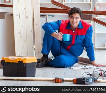 Young carpenter with notebook writing planning at construction repair job. Young carpenter with notebook writing planning at construction r