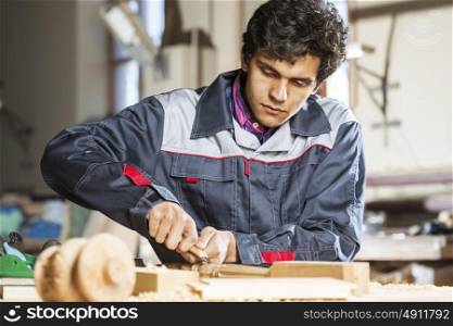 Young carpenter working with cutter in his studio. Carpenter at work