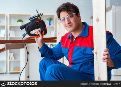 Young carpenter working with wooden planks