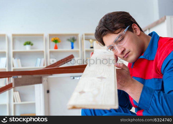 Young carpenter working with wooden planks