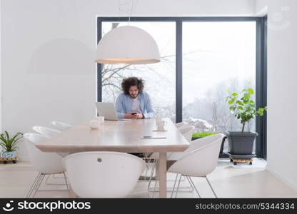 Young casual businessman using smartphone in the startup office