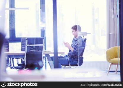 Young casual businessman using smartphone in the startup office