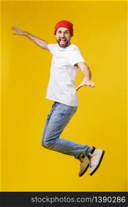 young casual man jumping for joy on yellow gold background.. young casual man jumping for joy on yellow gold background