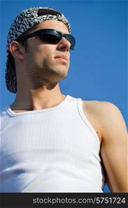 young casual man looking with the sky as background