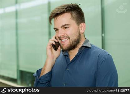 young casual man on the phone inside an office building