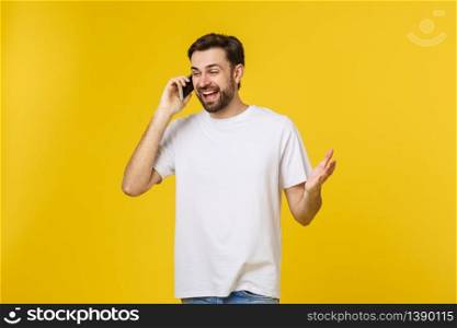 young casual man talking on the phone isolated on yellow background.. young casual man talking on the phone isolated on yellow background