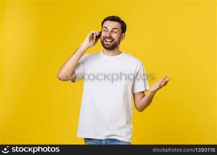 young casual man talking on the phone isolated on yellow background.. young casual man talking on the phone isolated on yellow background