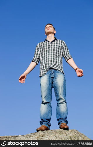young casual man with the sky as background