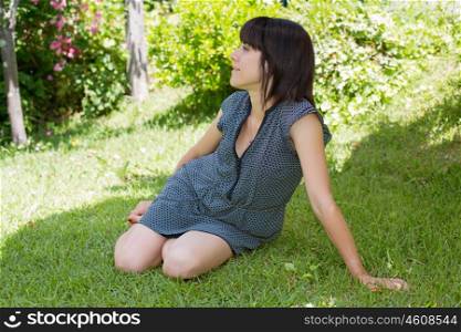 young casual woman posing seated, smiling, outdoors