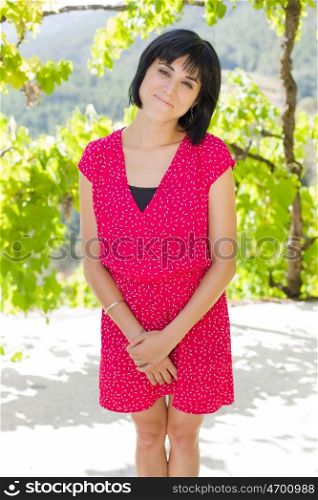 young casual woman posing, smiling at the camera, outdoors