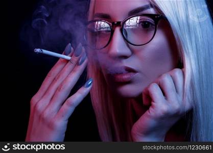 young Caucasian beautiful blonde woman with glasses Smoking. close-up portrait in neon light