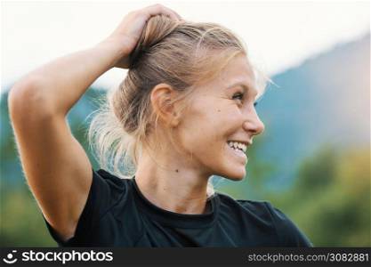Young Caucasian blond girl is holding her hair with hand