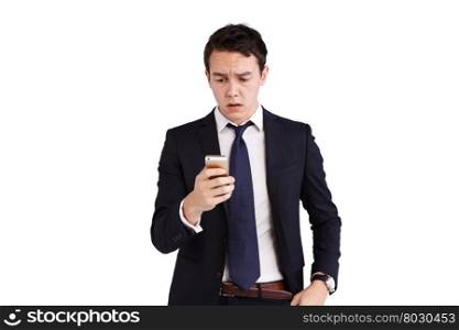 Young Caucasian business man frowning looking at mobile phone. A young Caucasian business man is frowning holding a moble phone.