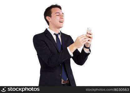 Young Caucasian business man holding a smart phone. A young Caucasian business man is holding and looking at a smart phone. Both of his hand is holding the smart phone. He is smiling. He is wearing a dark blue suit and neck tie. His head is slightly tilted up.