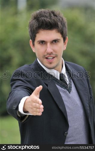 Young caucasian business man in a suite, pointing at camera to you