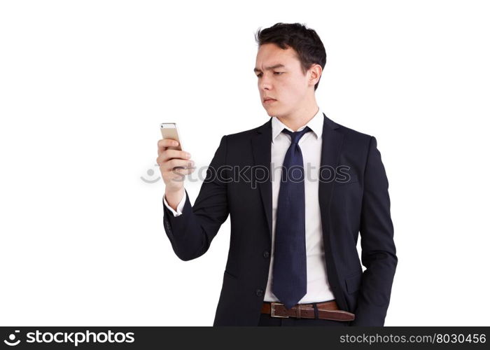 Young Caucasian business man looking at mobile phone. A young Caucasian business man is looking at his mobile phone. His finger is on the screen operating the smart phone.