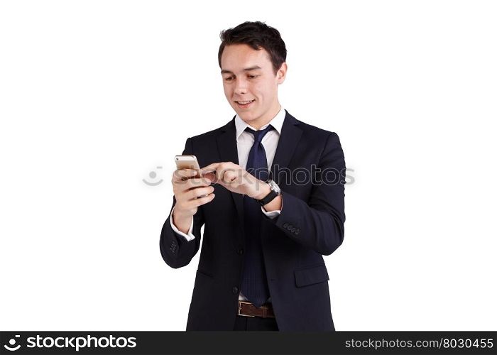 Young Caucasian business man looking at mobile phone smiling. A young Caucasian business man is holding a mobile phone smiling. He is holding the smart phone on one hand and operating with another hand.