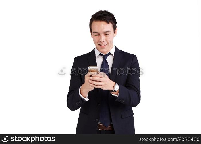 Young Caucasian business man looking at mobile phone smiling. A young Caucasian business man is holding a mobile phone smiling. His hand is on the screen operating the smart phone. He is looking at the smart phone with both hands holding holding the phone.