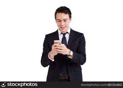 Young Caucasian business man looking at mobile phone smiling. A young Caucasian business man is holding a mobile phone smiling. His hand is on the screen operating the smart phone. He is looking at the smart phone with both hands holding holding the phone.