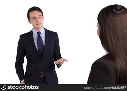 Young Caucasian business man reprimanding a business woman. A young Caucasian business man is reprimanding a business woman. He is looking unhappy.