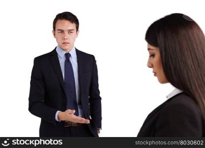 Young Caucasian business man reprimanding business woman. A young Caucasian man is reprimanding a business woman. He is frowining and looking angry.