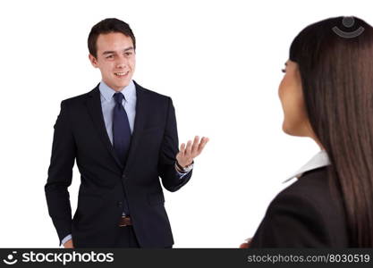 Young Caucasian business man smiling happily to a business woman. A young Caucasian business an is talking to a business woman. He is smiling happily and showing an open hand gesture.