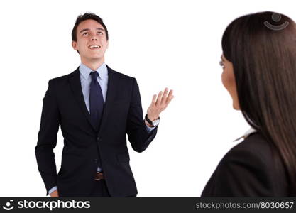 Young Caucasian business man smiling happily to a business woman. A young Caucasian business an is talking to a business woman. He is smiling happily and showing an open hand gesture.