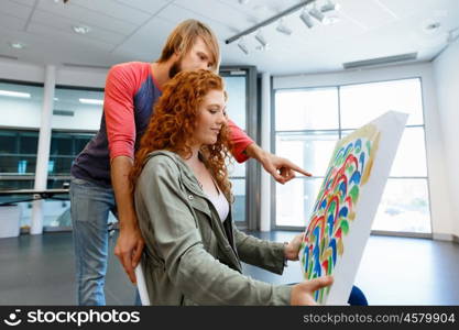 Young caucasian couple standing in a gallery and contemplating artwork. Young caucasian couple standing in a gallery and contemplating abstract artwork