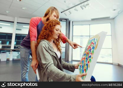 Young caucasian couple standing in a gallery and contemplating artwork. Young caucasian couple standing in a gallery and contemplating abstract artwork